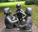 Drei sitzende Kinder im Schlosspark Schönhausen Berlin