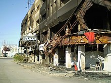 Photo d'une rue, le bâtiment au premier plan est éventré