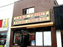 Storefront of establishment selling Lake Trout in Baltimore Lake Trout and Fried Chicken Shop on Greenmount Avenue, Baltimore, Maryland, USA.jpg