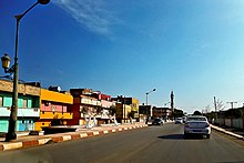 Fotografia de Souani com asfalto, estabelecimentos e carros