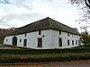 Hoeve met binnenplaats, van baksteen met speklagen van Naamse steen; vensteromlijstingen van Naamse steen met booglateien; op poort sluitsteen