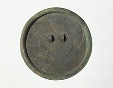 Espejo de bronce con una decoración lineal en relieve muy fino, que incluye motivos de «estrella radiante» y friso de tiras «positivas-negativas». Sitio de Daegok.[15]​[16]​