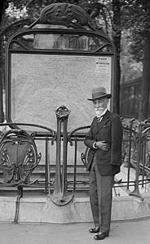 Fulgence Bienvenüe (1852-1936), patro de la Metroo de Parizo, antaŭ la enirejo al stacio Monceau