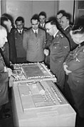 Bouhler presente numa reunião chefiada pelo líder da SS Heinrich Himmler. Ele esta de pé no fundo de óculos, atrás de Rudolf Hess.