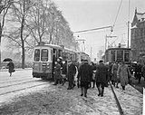 Drukte bij trams op Stationsplein te Amsterdam vanwege slechte weer. Links is gelede wagen nr. 601; 17 februari 1964.