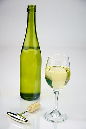English: Glass of White Wine shot with a bottl...