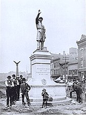 Workers finish installing Gelert's statue of a Chicago policeman in Haymarket Square, 1889. The statue now stands at the Chicago Police Headquarters. HaymarketPoliceMemorial.jpg