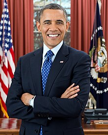 Obama standin up in tha Oval Office wit his thugged-out arms folded n' smiling