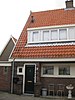 Blok met 8 keukenwoningen, zo genoemd vanwege destijds nieuwe plaatsing van keuken aan de voorzijde, aan de zijkant een houten topgevel, bouwstijl Amsterdamse School, samen met de poortgebouw langs de Purmerweg centraal deel van Tuindorp Nieuwendam