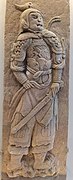 Song stone relief of a swordsman wearing mountain pattern and mail armour