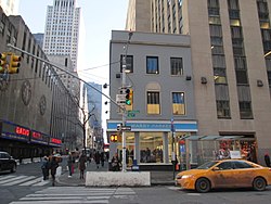 Budova 30 Rockefeller Plaza (vpravo) byla postavena kolem soukromého pozemku v severozápadním a jihozápadním rohu. Obchod Warby Parker uprostřed tohoto snímku nyní stojí na místě pozemku v severozápadním rohu 30 Rockefeller Plaza.