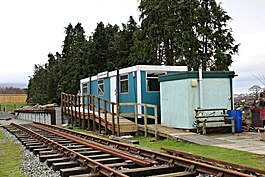 A short section of railway track, in front of a temporary building.