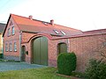 Bauernhof mit Wohnhaus, Seitengebäude und Hofmauer mit einem großen Torbogen und zwei kleinen Pforten, dazu Feldscheune