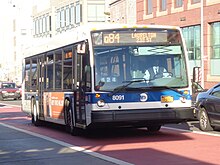 A Q84 bus using an offset red-painted bus lane in Jamaica, Queens