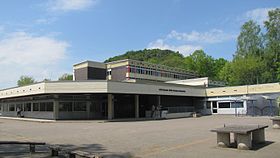 Blick über Teile des Schulhofs auf einen Teil des A-Gebäudes, im Hintergrund der Bielenberg