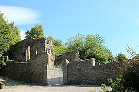 L'entrée du cimetière au premier plan et les vestiges de la collégiale