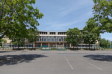 Aperçu de l'entrée du Palais des Sports de Dijon entre les arbres, où évolue la JDA Dijon