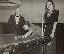 Joyce Gardner playing billiards, with thelma Carpenter standing to the left and an unknown referee to the right