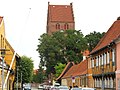 Looking down Kirkestræde (Church Street) in Køge. Køge's church (Sankt Nicolai Kirke is behind the trees)