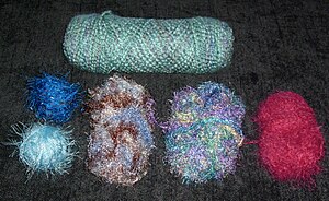An assortment of novelty yarns (bottom) with a...