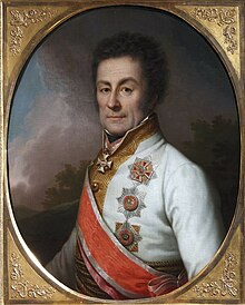 Klenau has dark curly hair; he wears a white military coat, and military decorations.
