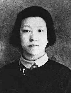 Photographie en noir et blanc du visage d'une jeune Chinoise aux cheveux noirs coupés au carré, vue de face en plan rapproché.