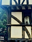 Close up of the first floor of the house, with a timber with a distinct curve embedded within the wall