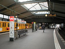 Station with a yellow train and a skylight