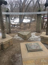 The Wokiksuye K'a Woyuonihan memorial site at Fort Snelling, with a pipestone encased in the center, surrounded by bundles of the four sacred medicines: sage, cedar, tobacco, and sweetgrass. Wokiksuye K'a Woyuonihan Memorial.jpg