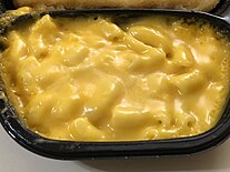 A serving of macaroni and cheese included as part of a frozen meal with frozen cheese sauce as an ingredient