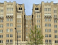 The top floors of a building with a grotesque on the edge