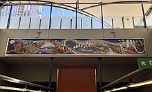 A wide mural sprawled high up and across the station's northern interior wall