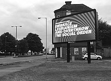 Digital billboard in Manchester UK displaying feminist/lesbian intersectional artwork by Martin Firrell Embrace Lesbianism - public art text by artist Martin Firrell.jpg