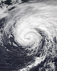 Satellite picture of Epsilon as a weakening Category 1 hurricane, with Bermuda visible to the southwest of the storm