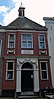 Schachthof. Hof met dertien woninkjes. Dubbele stenen pomp van 1730. Poortgebouw met voormalige Regentenkamer. Tentdak door fraaie schoorsteen bekroond, gebeeldhouwde ingang