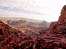 A color photograph showing the landscape of a desert town, prominently displaying its mountain ranges.