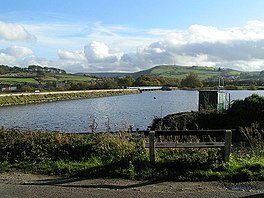 A bench overlooking a reservoir in rolling countryside