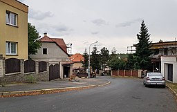 Střední část ulice Zdobnické, u ulice Želivská (na fotografii za červeným plotem) se lomí vpravo.