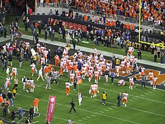 Clemson players celebrate in the end zone near the majority of their fans.