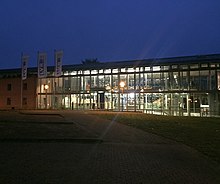 Blick auf da Gebäude mit dem Haupteingang in der Dämmerung. Das Museum ist hell erleuchtet.