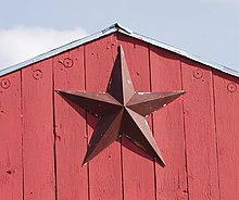 A barnstar, mounted on a wall, is seen as a lucky symbol in some parts of North America. BarnstarProud.jpg