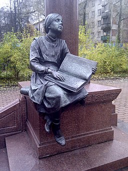 Blind reading girl near the Grot stela monument
