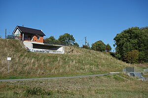 Staudamm mit Einlaufbauwerk und Überlauf, vom trockenen Becken aus gesehen