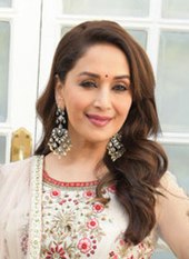 Madhuri Dixit menatap ke arah lain dengan senyum terlukis pada wajahnya.