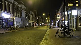 Nieuwe Ebbingestraat bij avond in de richting van de Grote Markt met op de achtergrond de Martinitoren