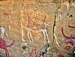 A drawing of a giraffe on a cave wall.