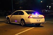 An unmarked Chevrolet Impala used by the Memphis Police Department. Flashing emergency lights are visible in the rear window. Unmarked cruiser blocking Elvis Presley Blvd Memphis TN 2013-11-22 004.jpg