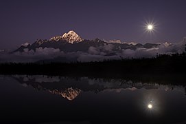 The reflection of Langtang Lirung in a pond in a moonlit night. Photograph: Ummid Shakya