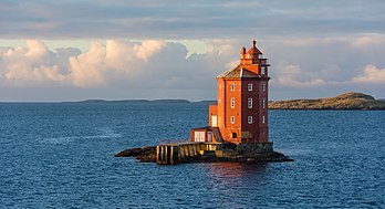 Farol Kjeungskjær (às vezes chamado “O Marinheiro Vermelho”), em um ilhéu que sinaliza a entrada de um fiorde (Bjugnfjorden) na comuna de Ørland, Noruega. O farol foi construído em 1880 e automatizado em 1987. Antes de ser automatizado, o faroleiro e sua família moravam nos andares inferiores do prédio. O farol de 17,5 metros de altura é feito de pedra com uma torre octogonal pintada de vermelho. É aceso todos os anos de 21 de julho a 16 de maio e fica desligado durante o final da primavera e início do verão devido ao Sol da meia-noite. (definição 6 000 × 3 257)