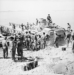 Ŝirma tanko estanta ŝarĝita sur pontonpramo de viroj de la dua dividado antaŭ transirado de la Irrawaddyorivero ĉe Ngazun, Birmo, 28 februaron 1945.
SE3155.jpg